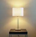 Lamp on table with painted wall background. Home energy utilities, electric lighting fixtures and modern interior decor