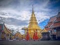 Lamphun, Thailand - June 6, 2016 : Three monks walking in temple with background golden pagoda at Wat Phra That Hariphunchai, The