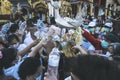 LAMPHUN, THAILAND - MAY 15, 2022: Monks and people pour auspicious water into large bowls to pay homage to the Buddha`s relics