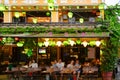 Lampions on restaurant and street cafe in Hoi An, Vietnam. People sitting in front of illuminated lanterns.