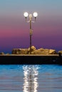 Lamppost on pier after sunet with magically colored sky in background Royalty Free Stock Photo