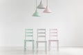 Lamps above chairs in mint, pink and grey color in white empty i