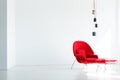 Lamps above red armchair in white living room interior with copy