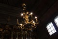 Lamps in the form of candles light on chandelier in ancient wooden Orthodox church Royalty Free Stock Photo