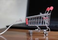 LAN cable and a small shopping cart on a table with a laptop on it - online shopping concept Royalty Free Stock Photo