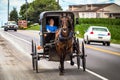 Lancaster, PA / USA - 7/4/2013: Amish woman riding a retro carriage on the street