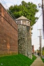 Prison guard tower, stone wall and razor wire.