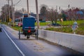 LANCASTER, USA - APRIL, 18, 2018: Outdoor view of the back of old fashioned Amish buggy with a horse riding at one side
