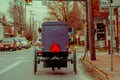 LANCASTER, USA - APRIL, 18, 2018: Outdoor view of the back of old fashioned Amish buggy with a horse riding on urban