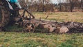 Land cultivation tractor plows the ground  a blue small tractor and a plow with three knives Royalty Free Stock Photo