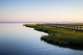 Land juts out onto water with a wood walkway