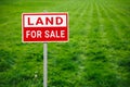 Land for sale plate sign, green lawn background Royalty Free Stock Photo