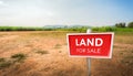 land for sale sign against trimmed lawn background. Empty dry cracked swamp reclamation soil Royalty Free Stock Photo
