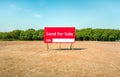 land for sale sign against trimmed lawn background. Empty dry cracked swamp reclamation soil, land plot for housing construction Royalty Free Stock Photo
