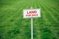 Land for sale sign against trimmed lawn background Royalty Free Stock Photo