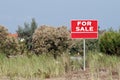 Land for sale sign in empty field Royalty Free Stock Photo
