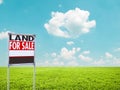 Land for sale sign on empty green field Royalty Free Stock Photo