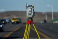 Land survey equipment set up on road with road becoming a hill