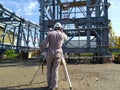 A land surveyor engineer during his work with surveying using theodolite or total station scanner Inside a mechanical site Royalty Free Stock Photo