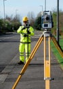 Land surveyor performing initial survey of the road levels and kerb lines before start of construction works using robotic