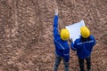 Land surveyor team standing working together at construction field consult study looking building location with floor plan Royalty Free Stock Photo