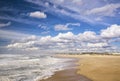 Landcape image of a streched out golden sand beach and cloudy sky in Nazare, Portugal