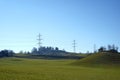 Landcscape with high voltage electric pylons in chain on the horizon. Early spring nature with cycling and hiking trial in the mil Royalty Free Stock Photo