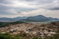 landfill surrounded by natural landscape, with mountains in the background