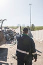 Landfill worker directing skid steer loader on the waste heap