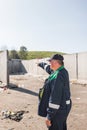 Landfill worker directing skid steer loader on the waste heap