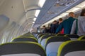 landing aircraft, people stand in the aisle between the seats and take out the luggage. exit queue