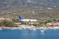 Landing of an airliner on the airport runway in the summer, passing over the marina Royalty Free Stock Photo