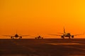 Landing airplanes against colorful sky at sunset. Travel background with passenger plane. Evacuation Royalty Free Stock Photo