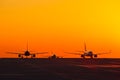 Landing airplanes against colorful sky at sunset. Travel background with passenger plane. Evacuation Royalty Free Stock Photo