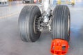 Landing gear airplane in hangar chassis rubber close-up, wheel supported by a brake red shoe Royalty Free Stock Photo