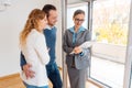 Landlady or realtor showing lease agreement to new tenants Royalty Free Stock Photo