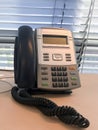 Landline phone on a table with jalousies on a background