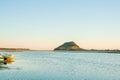 Landmark Mount Maunganui on distant horizon at sunrise with old-fashioned clinker dinghy on beach Royalty Free Stock Photo