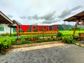 A landmark sign of a Warung Tepi Sawah with green and yellow paddy, mountain and sky with white cloud, perlis, malaysia.
