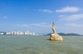 Landmark of Zhuhai city of China. Statue of Fish Woman, fisher girl stature with background of sea, island, and tall buildings Royalty Free Stock Photo