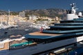 Landmarks of Monaco through decks of huge yacht of blue color in port Hercule at sunny day, glossy board of the motor Royalty Free Stock Photo