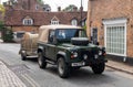 Landrover Defender pulling truck with a bale of hay