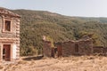 Landscape of an abandoned old stone house with forest green mountains in the background Royalty Free Stock Photo