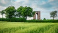 Landscape of green grass field, trees and tower. Royalty Free Stock Photo