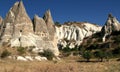 Amazing mountains with caves inside and snow-white rocks in the background in Zemi Valley near Goreme in Cappadocia Royalty Free Stock Photo