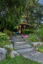 Landscape architecture with pink flowers and ornamental grasses for summer garden with water feature Royalty Free Stock Photo