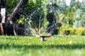 Landscape automatic garden watering system with different rotating sprinklers installed on turf. Landscape design with