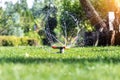 Landscape automatic garden watering system with different rotating sprinklers installed on turf. Landscape design with