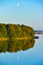 The landscape of autumn yellow and green forest trees are reflected in the water of the lake in the evening Royalty Free Stock Photo