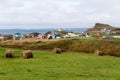 Landscape of bales of hay and small colourful traditional houses on Havre-aux-Maisons Island